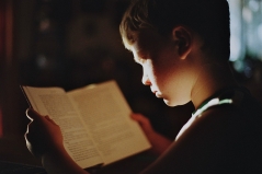 Een jongen die een boek leest