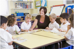 Een juf met basisschoolkinderen om zich heen