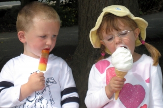 Jongen kijkt jaloers naar meisje met groter ijsje